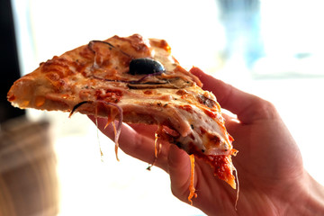 Hand taking slice of delicious pizza