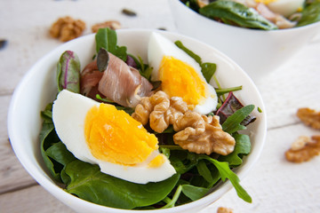 Salad with eggs, walnuts, arugula, lettuce and Parma ham