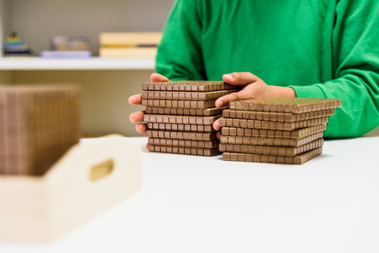 Child placing some blocks to count numbers is his house, concept of homeschooling.