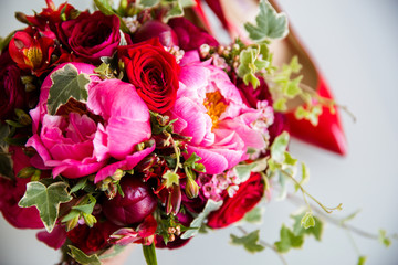 Red roses with pink peonies in the bridal bouquet