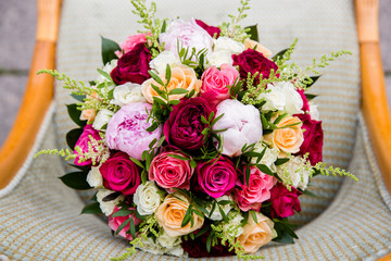 Buds of roses and peonies in a luxurious wedding bouquet on the chair, top view