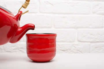 Pour tea into a red cup.