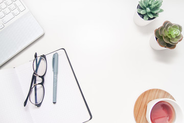 Workspace with laptop, notebook, sketchbook, succulent, cup of tea on white background. Flat lay, top view office table desk. Freelancer working place. copyspace