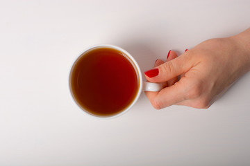 Hand with cup of tea.