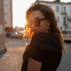 Portrait of a modern beautiful young hipster woman in stylish sunglasses in black fashionable...