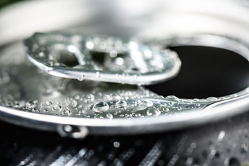 aluminum soda can neck with ring close-up covered with water drops