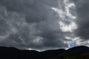 Storm cloud over the mountains in dark sky.