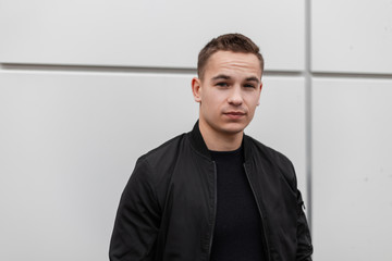 Pretty cute attractive young man in a vintage black jacket in a stylish T-shirt with a fashionable...