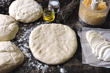Cooking homemade pizza. Pizza dough, flour, mozzarella and grated cheese. Flat Lay.