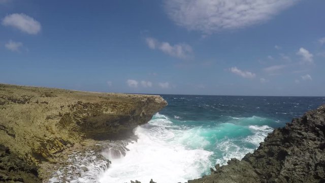  sea water spaying high in the breakers due to the rough surf and waves at a cliff of the east coastline of tropical Bonaire island in the caribbean