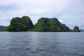 Fototapeta na wymiar Tropical island in still sea. Green mountain marine landscape. Philippines island hopping banner template.