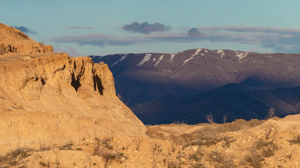 Open sky view of foothills, mountains, and sand/gravel quarry near Boise