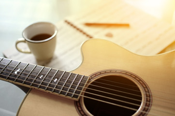 Acoustic guitar and  a cup of coffee on  background