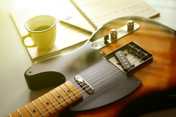  Electric guitar and  a cup of coffee on wood background