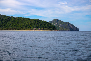 Fototapeta na wymiar Tropical island in still sea. Green mountain and tourist resort. Philippines island hopping banner template.