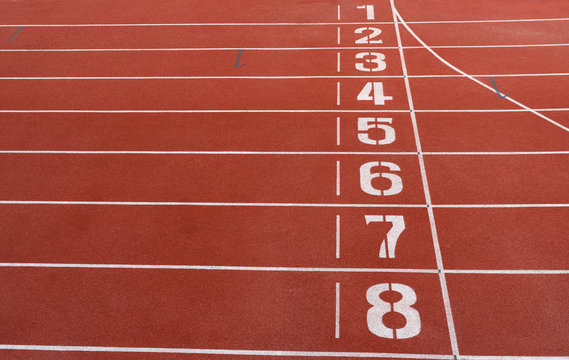 Numbers on red running track. Start and Finish point of a race track in a stadium.