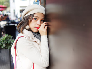 Street photography of beautiful young brunette woman in sunny autumn city. Outdoor fashion portrait of glamour young Chinese stylish lady. Emotions, people, beauty and lifestyle concept.