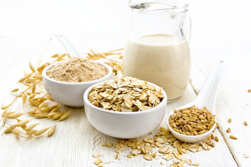 Oat flakes with flour and milk on wooden board
