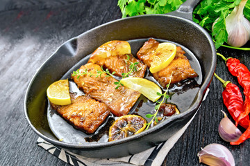 Salmon with sauce in pan on black board