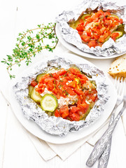 Salmon with vegetables in plate on wooden board