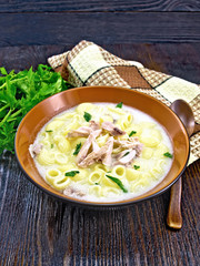 Soup creamy of chicken and pasta in plate on wooden table