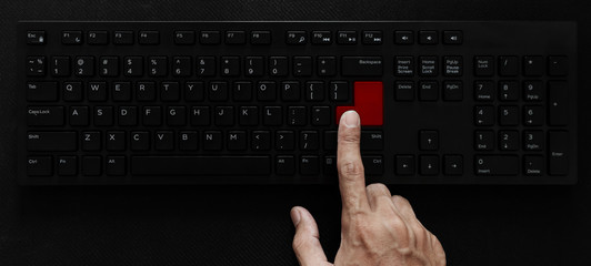 Top view, Hand pushing red button on computer keyboard