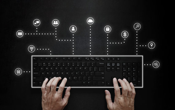 Hand typing on computer keyboard with application programming interface icons