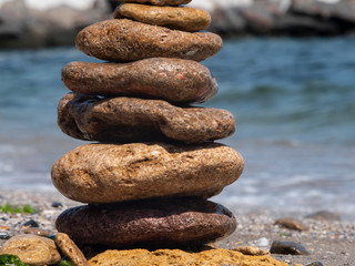 Fototapeta na wymiar sea ​​flat stones are standing one on another on the sea shore