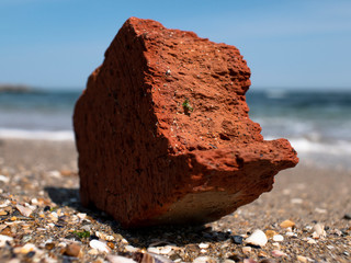 red brick on the seashore against the background of the sea and blue sky