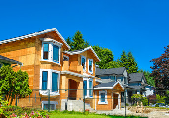 Brand new residential house is under construction. The house has been framed and plywood installed. The windows installation has been finished