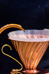 Showcase Drip coffee maker and Barista pouring water on ground coffee with filter.