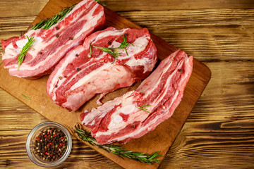 Raw pork ribs with spices and rosemary on wooden table. Top view