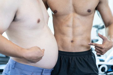 Two naked men comparing belly fat and slim six pack