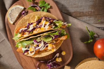 Traditional mexican taco with chicken and vegetables on wooden table. Latin american food.