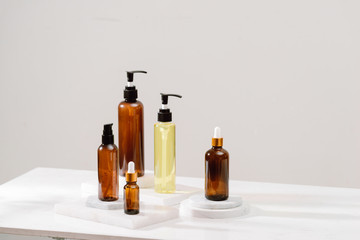 Spa cosmetics in brown glass bottles on gray concrete table. Copy space for text. Beauty blogger, salon therapy, branding mockup, minimalism concept