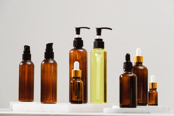 Spa cosmetics in brown glass bottles on gray concrete table. Copy space for text. Beauty blogger, salon therapy, branding mockup, minimalism concept