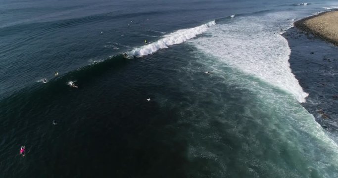 SLOW MOTION SURFER RIDING WAVE. Surfers in the line of of point break. 