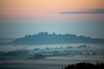 Fototapeta na wymiar Early morning mist over farmland and woodland in rural Hampshire
