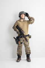 白背景に迷彩服を全身着たかっこいい女の子がエアーガンを持っているサバイバルゲームサバゲー体験 