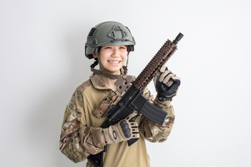 白背景に迷彩服を全身着たかっこいい女の子がエアーガンを持っているサバイバルゲームサバゲー体験 