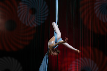 Circus artist acrobat performance on canvases. The girl perform acrobatic elements in the air.