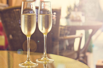 two glasses with champagne on a table in a restaurant
