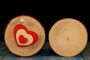beautiful red heart is nailed to a wooden saw cut on a black background