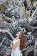 Beautiful long-haired bride in a magnificent white dress in nature