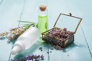 cream, shampoo, perfume product samples with lavender on old blue wood table background