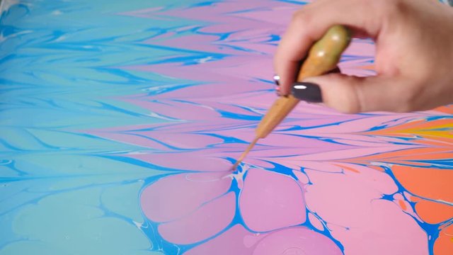 Ebru art. Painting technique. Female artist painting ebru technique - art on water. Drawing with brush followed by paper prints. Colorful paints with waves. Hobby, arts, culture concept. 4k