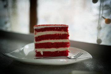Strawberry and almond cake on table in coffee shop. Slices red velvet cake on a white plate. Sweets for holiday.
