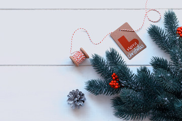 Christmas gifts, pine branches, red berries on white background. Flat lay, top view. Copy space.