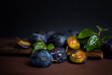 Red cherry plum with green leaves on dark background. Toned image with copy space.