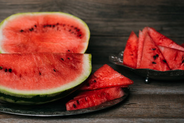 Fototapeta na wymiar Healthy watermelon with mint, a piece of watermelon, and a striped watermelonon a wood background.